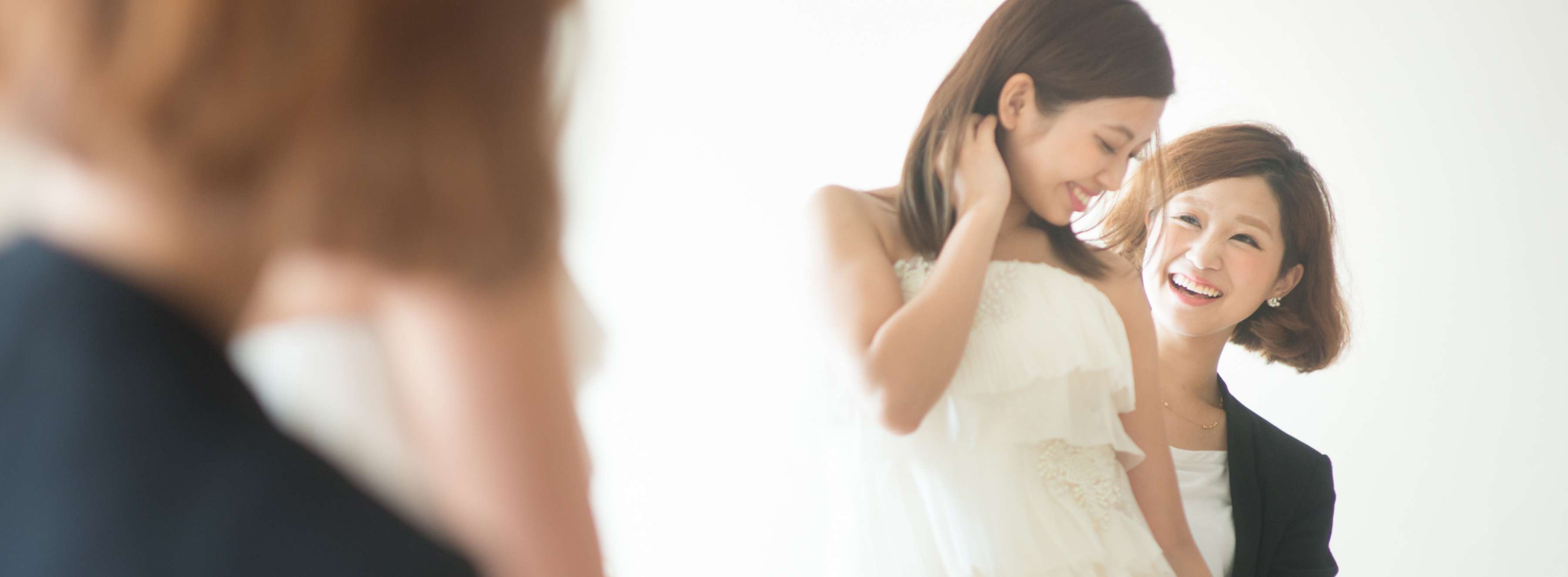ドレス選びを手伝うスタッフと楽しむ新婦