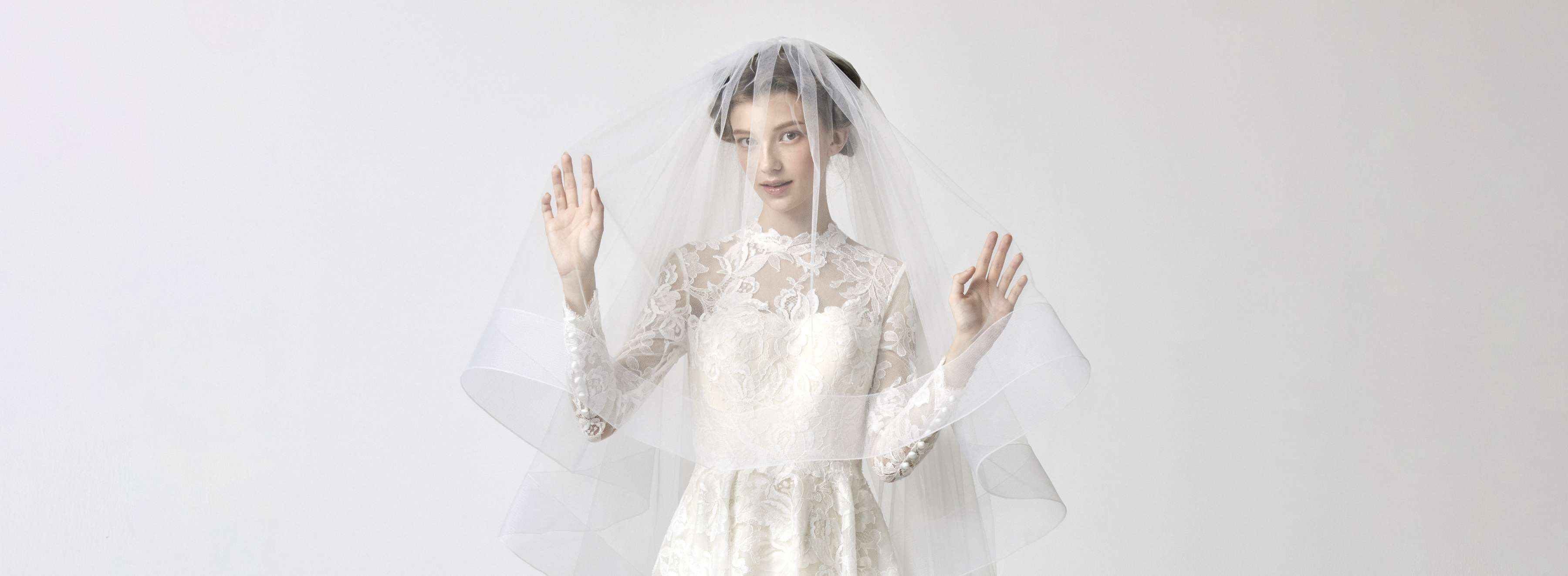 レースの繊細なウエディングドレスのベールをかぶった新婦